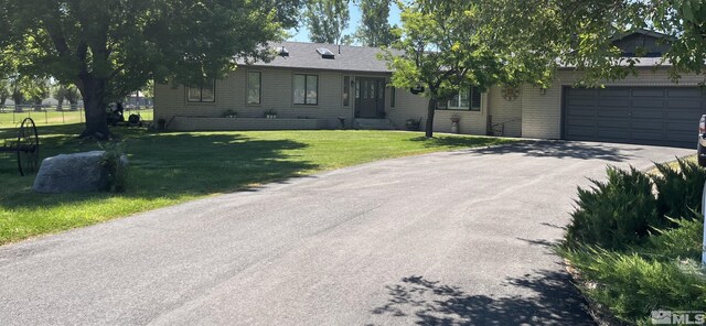 ranch-style home with fence, a front yard, aphalt driveway, and a garage