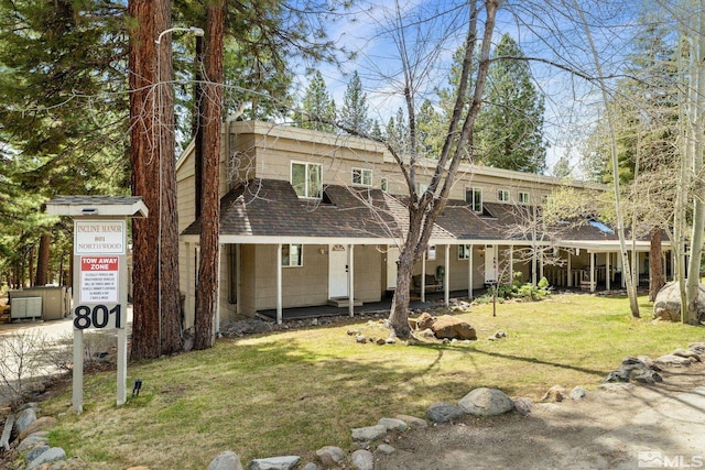 view of front of house featuring a front lawn, roof with shingles, and a porch