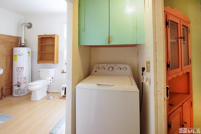 washroom featuring washer / clothes dryer, wood finished floors, gas water heater, and cabinet space