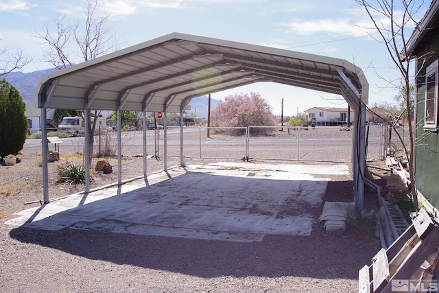 view of parking featuring fence and a detached carport