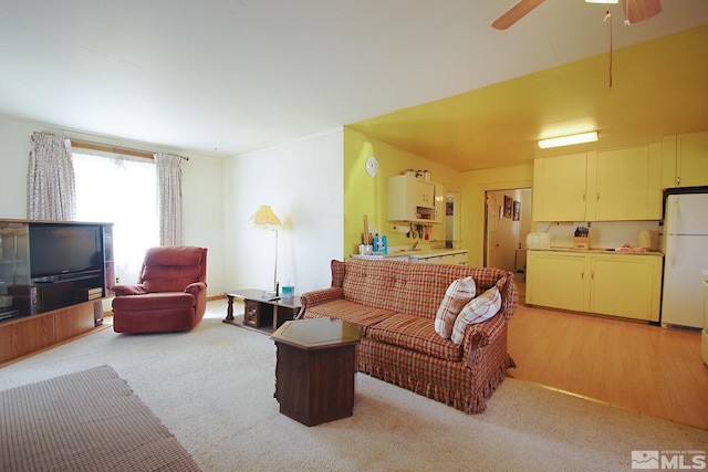 living room with light colored carpet and ceiling fan