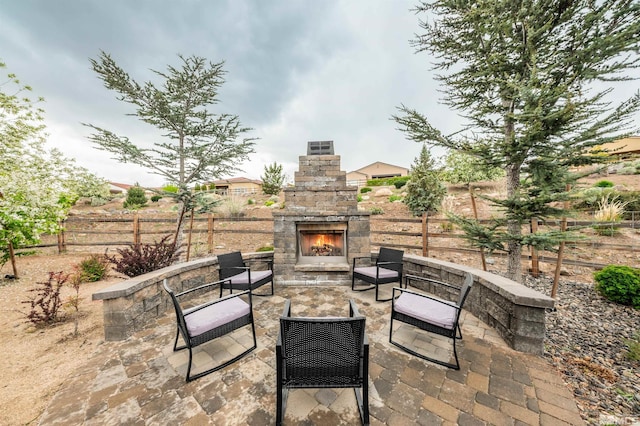view of patio featuring an outdoor stone fireplace and a fenced backyard