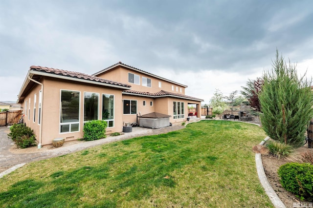 back of property with a tiled roof, a patio area, stucco siding, a lawn, and a fenced backyard