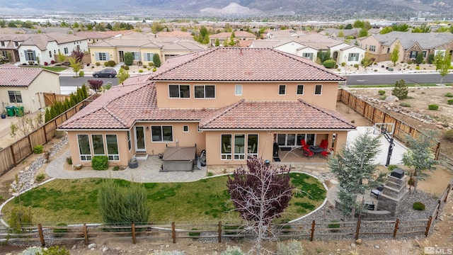 back of property featuring stucco siding, a patio, and a residential view
