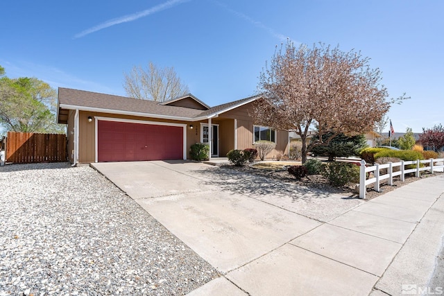 ranch-style house with concrete driveway, an attached garage, and fence