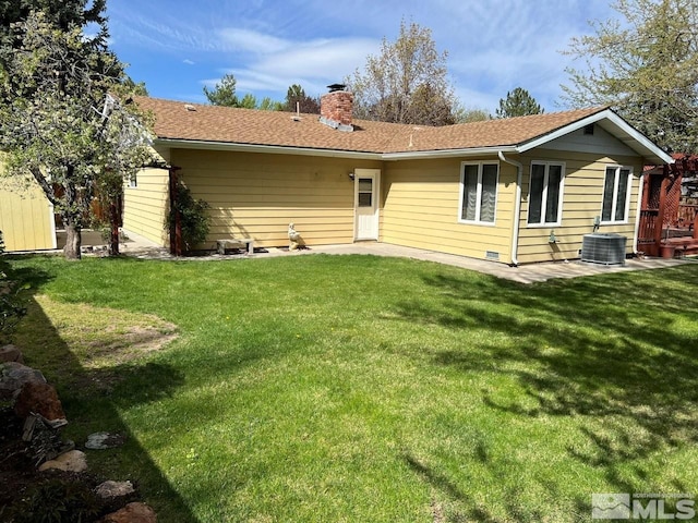 back of house with a lawn, central AC unit, and a chimney