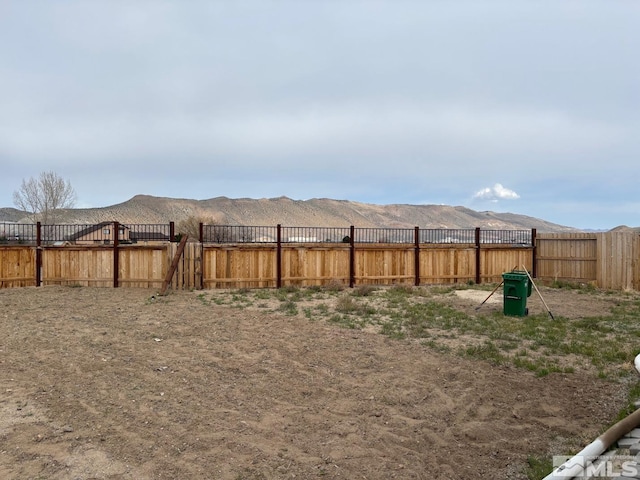view of yard featuring fence and a mountain view