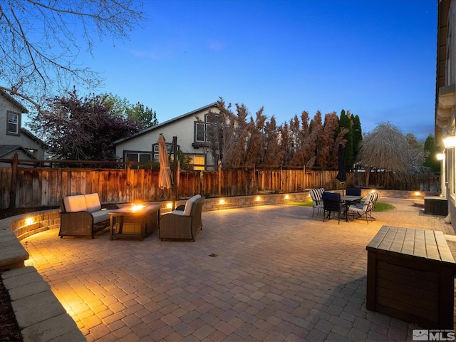 view of patio with a fire pit, outdoor dining space, and a fenced backyard