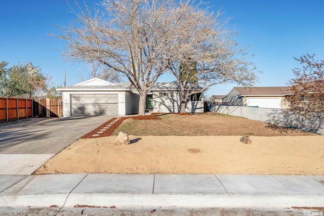 single story home with fence, concrete driveway, and a garage