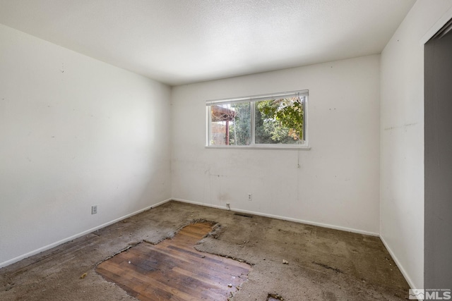 spare room featuring carpet flooring and baseboards