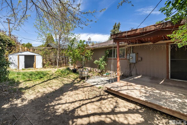 view of yard with an outdoor structure, a shed, and a deck