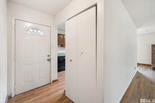 entryway with light wood-style flooring and baseboards