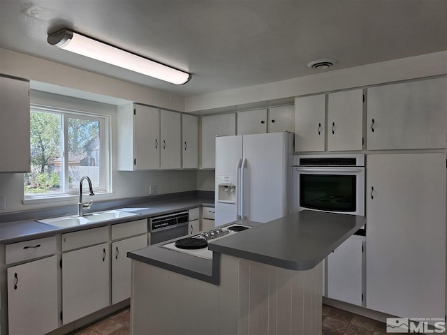 kitchen with a sink, white refrigerator with ice dispenser, stovetop, oven, and dishwashing machine