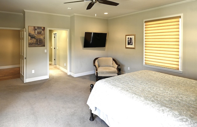 carpeted bedroom featuring baseboards, ornamental molding, and a ceiling fan