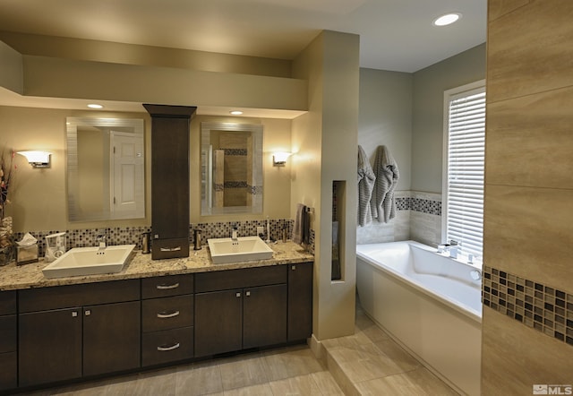 bathroom with double vanity, a sink, a bath, and tiled shower