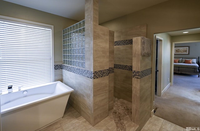 full bath with a soaking tub, tile patterned floors, tiled shower, and ensuite bathroom