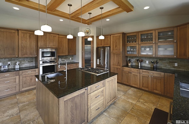kitchen featuring a sink, appliances with stainless steel finishes, backsplash, and brown cabinets