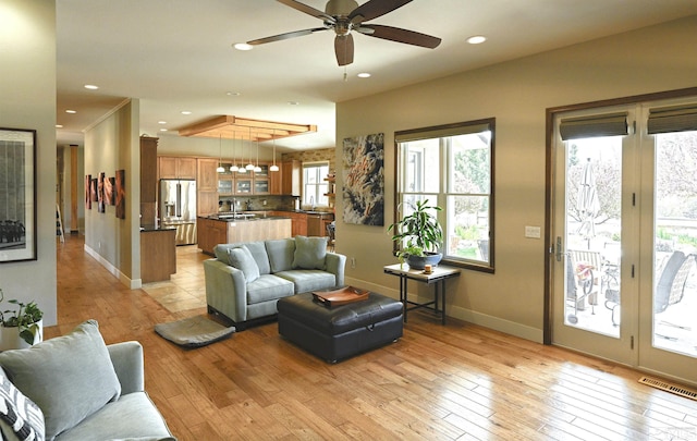 living area featuring baseboards, visible vents, and plenty of natural light