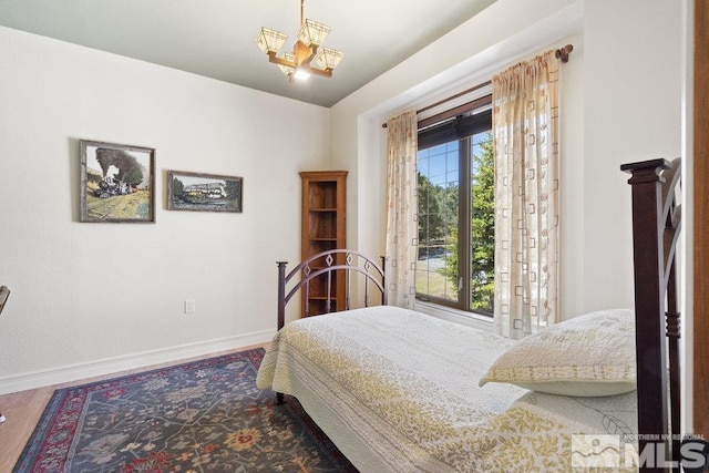 bedroom with baseboards and wood finished floors