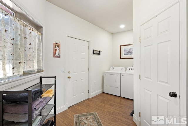 laundry area featuring recessed lighting, laundry area, baseboards, washer and dryer, and wood finished floors