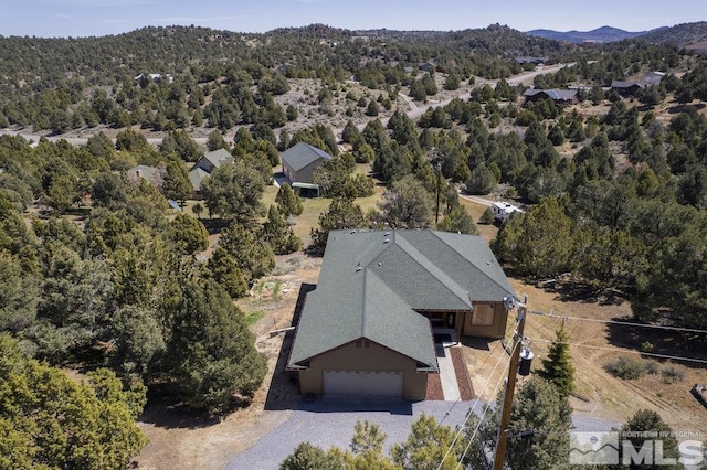 birds eye view of property with a mountain view and a view of trees