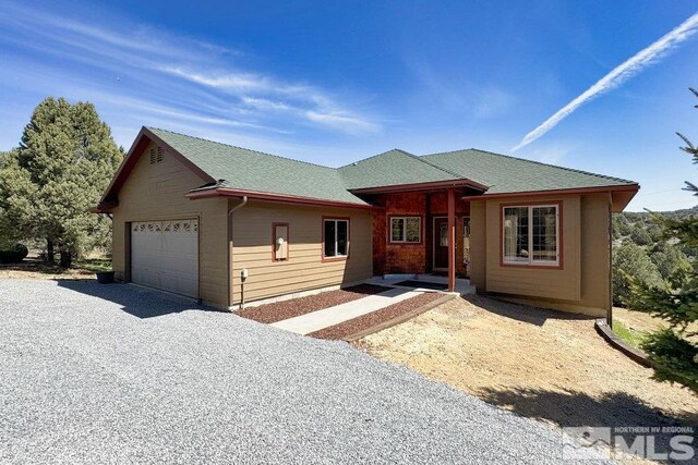 view of front of house featuring driveway, a shingled roof, and an attached garage