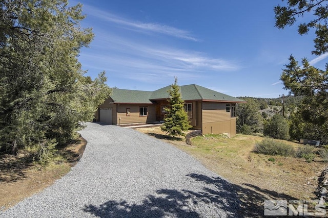 view of front facade featuring gravel driveway and an attached garage