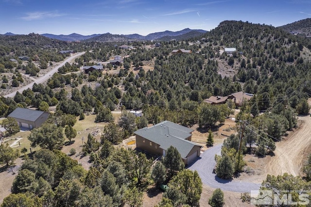 aerial view featuring a wooded view and a mountain view