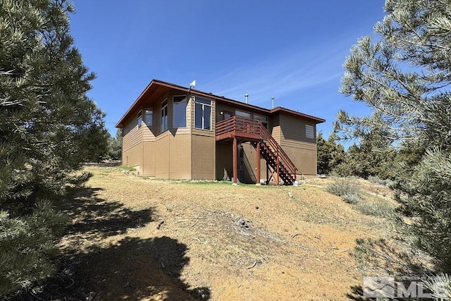 rear view of property with a deck and stairs