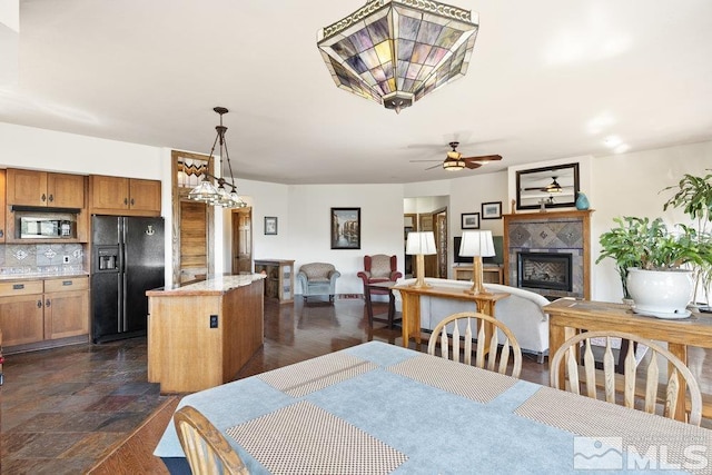 dining room with a ceiling fan and a fireplace