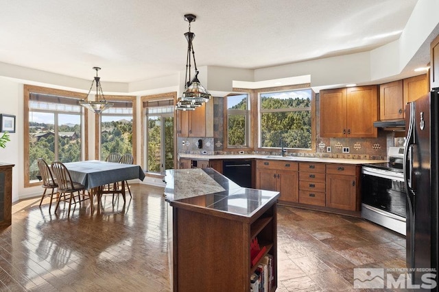 kitchen featuring black appliances, brown cabinets, backsplash, and a sink