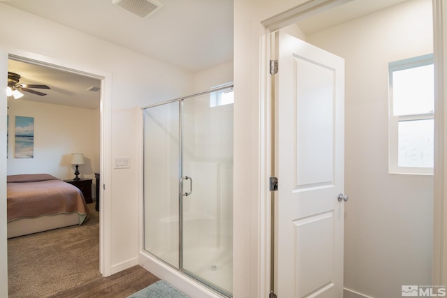 full bathroom featuring visible vents, wood finished floors, a shower stall, and connected bathroom