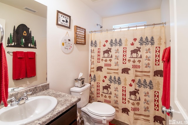 bathroom featuring toilet, curtained shower, visible vents, and vanity