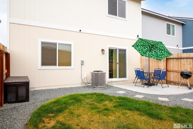 back of property with cooling unit, fence, a yard, and a patio area