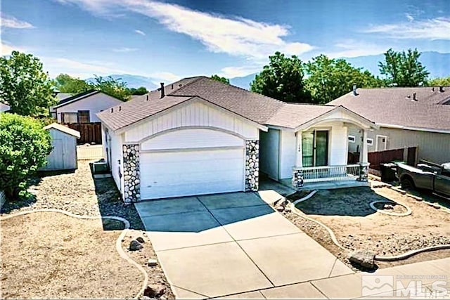 ranch-style house with fence, a storage shed, driveway, and an attached garage