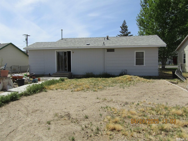 rear view of house featuring fence and entry steps