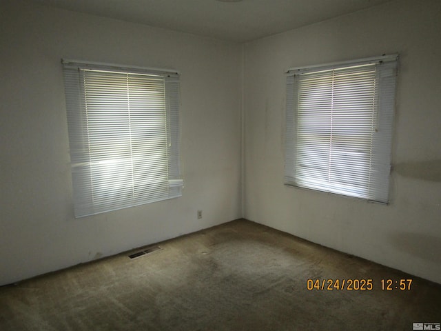 unfurnished room featuring visible vents and carpet