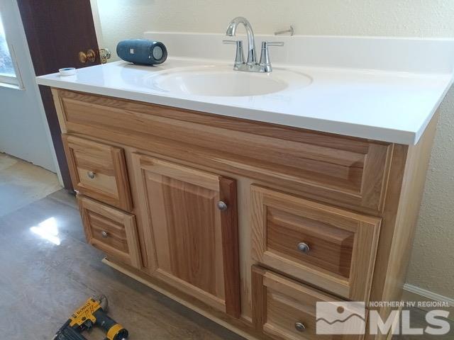 bathroom featuring a textured wall and vanity