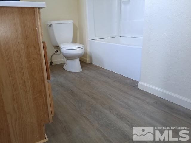 full bath featuring wood finished floors, toilet, and baseboards