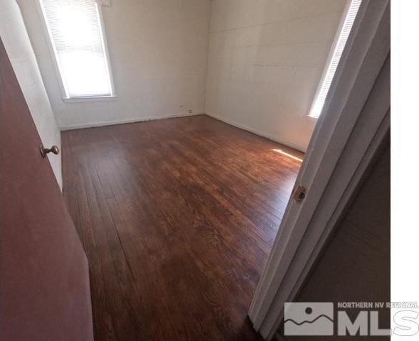 empty room featuring baseboards and wood finished floors