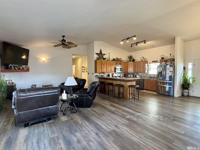 living room with ceiling fan, lofted ceiling, and dark wood-type flooring
