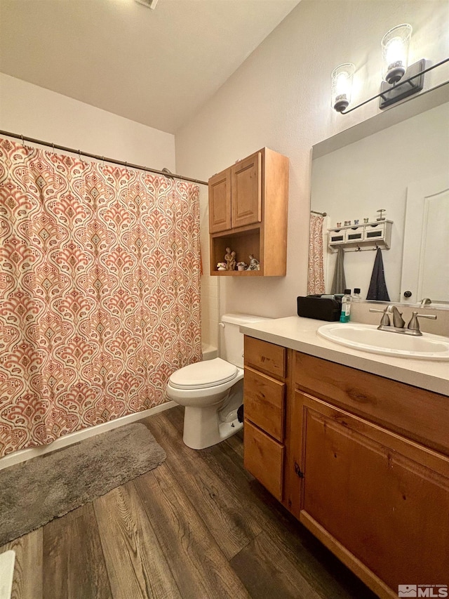 full bathroom featuring wood finished floors, shower / bath combination with curtain, toilet, and vanity