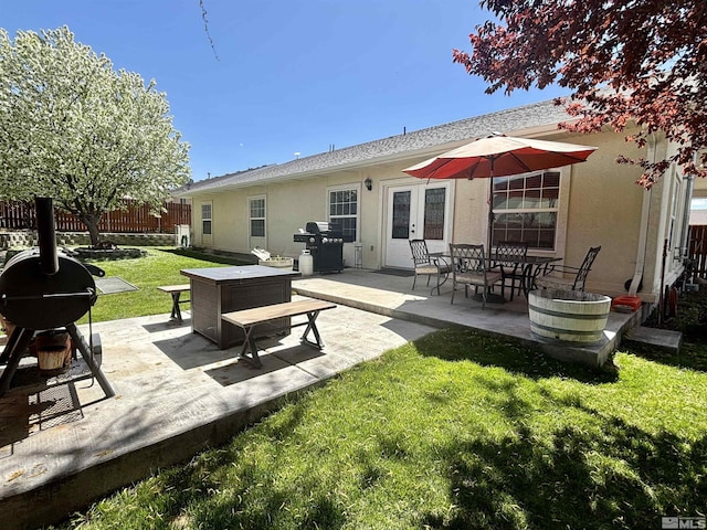 back of house featuring fence, a patio area, stucco siding, and a lawn
