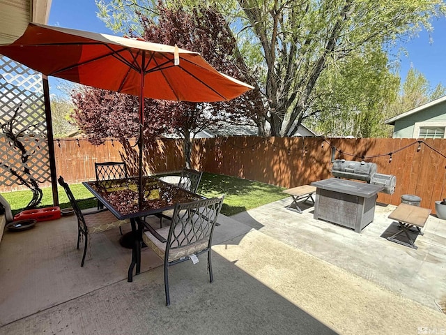 view of patio with outdoor dining area, a fenced backyard, and an outdoor fire pit