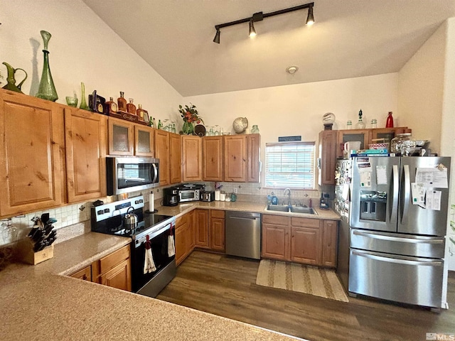 kitchen featuring dark wood-style floors, a sink, track lighting, light countertops, and appliances with stainless steel finishes