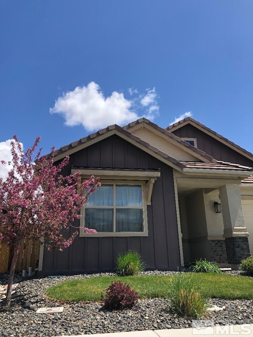 view of home's exterior featuring brick siding, board and batten siding, and fence