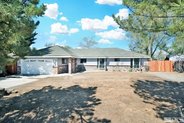 single story home with fence, an attached garage, driveway, and stone siding
