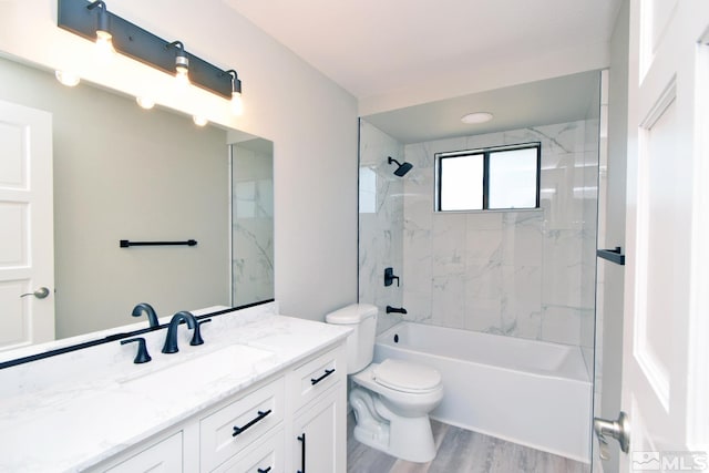 bathroom featuring vanity, washtub / shower combination, wood finished floors, and toilet