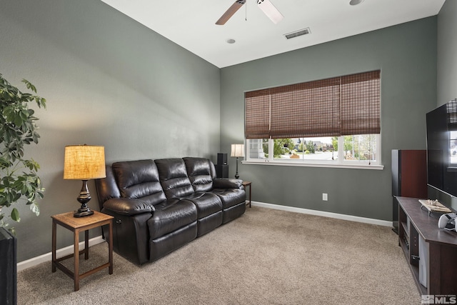 living area with visible vents, a ceiling fan, baseboards, and carpet floors