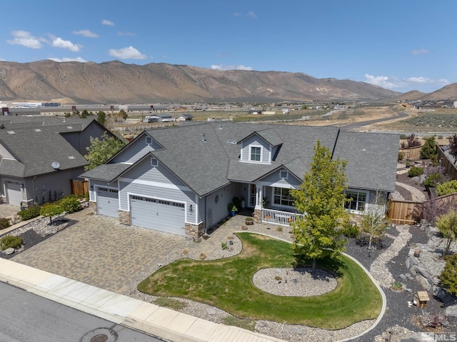 exterior space featuring fence, an attached garage, a shingled roof, decorative driveway, and covered porch